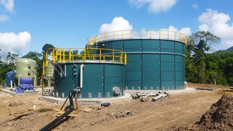 Green epoxy coated bolted steel tank with yellow access railings for liquid fertilizer storage